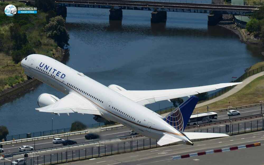 Самолет пролетает над автомобильной дорогой