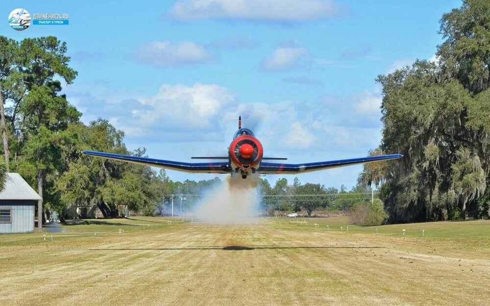 Небольшой винтовой самолет на посадке над полем